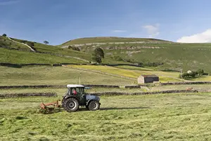 : Hurlimann tractor with tedder, turning hay in upland meadow