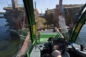 Transports Prints: Interior of John Deere 1010E Forwarder loading logs onto timber barge