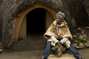 Southern Africa Prints: Inyanga herbal healer sitting outside hut in traditional Basutho village