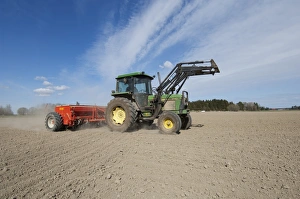 John Deere 2140 tractor with Tume seed drill, sowing arable crop in dusty field, Sweden, may