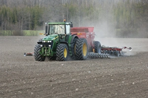 John Deere 7720 tractor with Overum seed drill, drilling arable field, Sweden, may