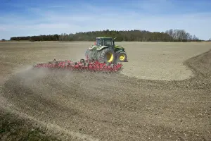 John Deere 7720 tractor with Vaderstad NZ-Aggressive-800 harrows, harrowing arable field, Sweden, may