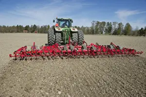John Deere 7720 tractor with Vaderstad NZ-Aggressive-800 harrows, harrowing arable field, Sweden, may