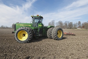 John Deere 9400 tractor with harrows, harrowing arable field, Tierp, Uppsala, Sweden, may