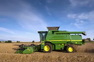 John Deere combine harvester, harvesting Barley (Hordeum vulgare) crop, discharging chaff and straw waste from back