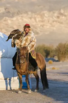 Golden Prints: Kazakh hunter on horseback with hooded Golden Eagle (Aquila chrysaetos)