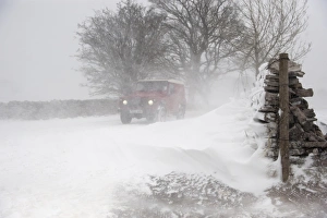Cars Prints: Land Rover travelling along rural road during severe snowstorm