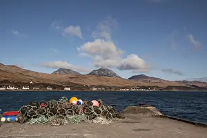 Pots Prints: Lobster pots on Jura Pier with the village of Craighouse and the Paps of Jura