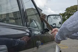 Cars Prints: Man trying to break pick-up window with metal bar in farmyard, Lancashire, England, August