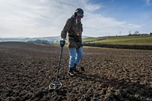 Pastime Prints: Man using metal detector in field