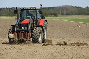 Massey Ferguson 6290 tractor with front loader forks, removing large stones from cultivated arable field, Sweden