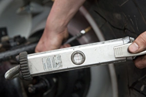 Pumps Prints: Mechanic checking tyre pressure in tractor tyres, England, october