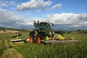 Mowing second cut grass with front and rear mounted mower conditioners on Fendt tractor, Cumbria, England, september