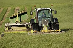 Mowing second cut grass with front and rear mounted mower conditioners on Fendt tractor, Cumbria, England, september