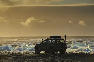 Cars Prints: Nissan Patrol 4x4 tour guide vehicle at edge of glacial ice in lake at dusk