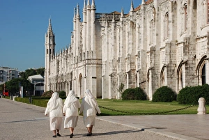 Monasteries Prints: Three nuns walking outside late-Gothic Monastery
