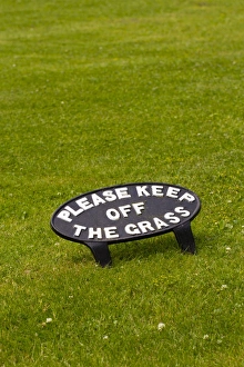 Iron Prints: Please Keep Off The Grass cast iron sign on lawn, Dyfed, Wales, July