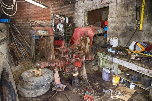 Indoor Prints: Old International 454 tractor in farm workshop, Sheffield, South Yorkshire, England, March
