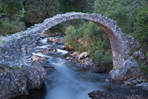 Trending: Old packhorse bridge over river at dusk