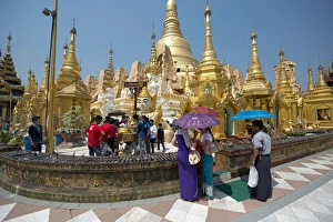 Holy Prints: People with umbrellas at Buddhist gilded pagoda and stupa