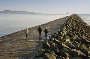 Protects Prints: People walking on sea wall protecting harbour entrance
