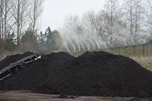Spray Prints: Peppermint perfume spraying over green compost heap at municipal waste site