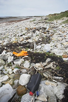 Pollution Prints: Plastic rubbish along high tide mark on deserted beach