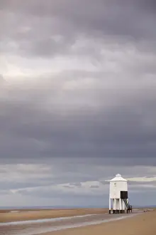 Rains Prints: Rainclouds and low wooden pile lighthouse on beach at low tide
