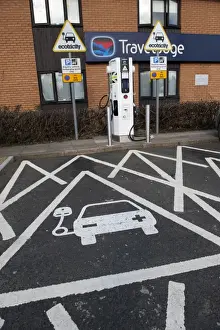 Reserved parking bay at recharging point for electric cars at motorway service area, England, April