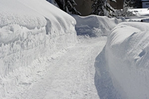 Drifting Prints: Road cleared through snowdrifts, Davos, Graubunden, Swiss Alps, Switzerland, january