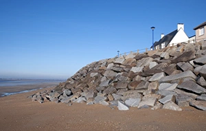 Protects Prints: Sea defence boulders and houses, St. Martin de Brehal, Manche, Normandy, France, December