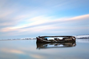 Ship Prints: Snow covered wreck of old barge in tidal river at sunset