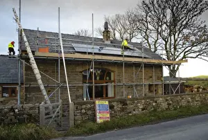 Solar power, photovoltaic panels being fitted on house roof, near Chipping, Lancashire, England, november