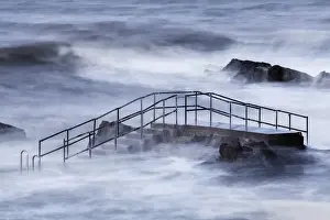 Tide Prints: Steps of tidal swimming pool above breaking waves during incoming tide on windy morning