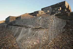 Defence Prints: Storm damage to shingle filled wire gabions on beach