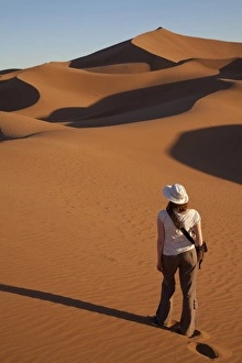 Holidays Prints: Tourist standing on desert sand dunes, Erg Chegaga, Sahara, Morocco, may