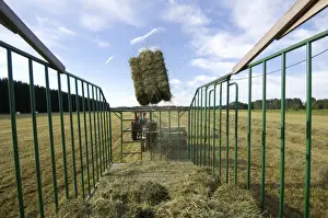 Trailer Prints: Tractor baling hay crop, baler tossing small bales into wagon, Sweden