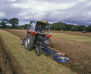 Plough Prints: Tractor ploughing stubble field during ploughing competition, Wales
