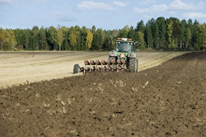 Plough Prints: Tractor with reversible plough, ploughing arable field, Sweden, september