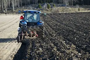 Plough Prints: Tractor with reversible plough, ploughing stubble field, Sweden, november