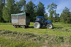 Trailer Prints: Tractor with wagon of grass for silage, in cut field, Alunda, Uppsala, Sweden, june