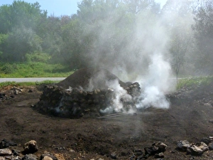 Burning Prints: Traditional charcoal production, burning olive logs to produce charcoal, Greece, april