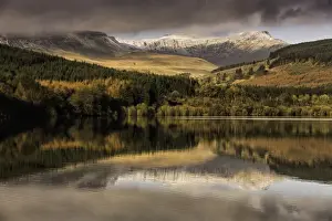 Reservoirs Prints: Trees and snow covered hills reflected in reservoir at sunrise