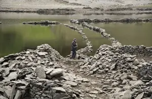 Reservoirs Prints: Upland reservoir with low water level and remains of submerged village exposed after dry summer