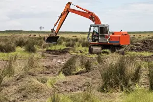 Using a digger excavator for habitat restoration work on Deepdale Marsh, Burnham Deepdale, North Norfolk