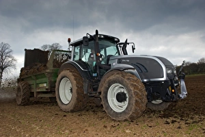 Trending: Valtra T151 tractor with muck spreader, spreading muck on arable field, England, march
