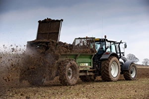 Valtra T151 tractor with muck spreader, spreading muck on arable field, England, march