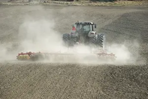 Valtra tractor with Vaderstad NZA-800 and Vaderstad RS-820 harrows and rollers, cultivating dusty arable field, Sweden