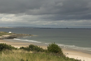 Stormy Prints: View of beach and coastline with stormy sky, Bamburgh, Northumberland, England, august