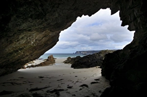 Sandy Prints: View of beach from inside rocky cave mouth